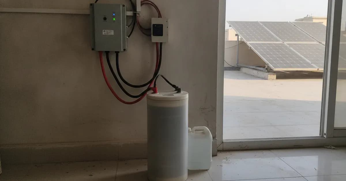 Two tall tubular batteries on a metal stand wired to a wall-mounted solar inverter and breaker box. — SolarNevs spec card