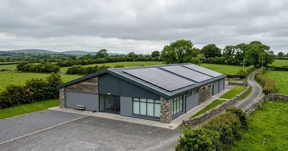 Solar panels installed on the roof of an Irish community building under overcast skies — SolarNevs spec card
